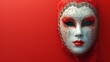   A mask with a woman's face centrally positioned, set against a solid red background ..Or, for a more descriptive version:.