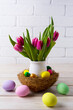 Easter table centerpiece with  nest and pink tulips in flower pot