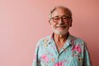 Portrait of an old man with a beard in a turquoise shirt on a pink background
