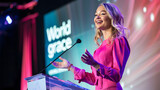 Fototapeta Most - A beautiful woman in her mid-30s with blonde hair is giving an inspiring speech on stage at the world's most popular tech conference