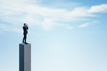 Canvas Print - Side view of young businessman on concrete bar looking into the distance. Bright blue sky background. Strategy, forecast and goal concept. Mock up place for advertisement.