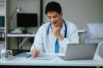 Wall Mural - Doctor working on laptop computer and tablet and medical stethoscope on clipboard on desk, electronics medical record system EMRs concept.