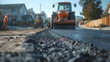 Asphalt workers and machinery were working on paving a new road in a developing area