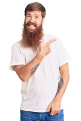 Poster - Handsome young red head man with long beard wearing casual white tshirt cheerful with a smile of face pointing with hand and finger up to the side with happy and natural expression on face