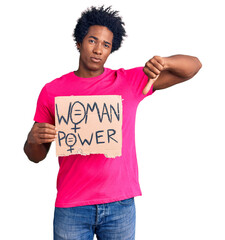 Sticker - Handsome african american man with afro hair holding woman power banner with angry face, negative sign showing dislike with thumbs down, rejection concept