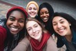 A vibrant group of young women share a joyful moment capturing a group selfie, expressing friendship and happiness. Joyful Young Friends Taking Group Selfie Together
