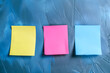 Colorful sticky notes on blue wall. Top view with copy space