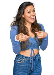 Wall Mural - Young hispanic girl wearing casual clothes pointing fingers to camera with happy and funny face. good energy and vibes.