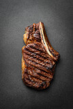 Fototapeta Desenie - Steak. Grilled steak on the bone. Roasted piece of meat. Free space for text.