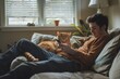 Young man relaxing with his cat on a cozy couch by the window while using a smartphone