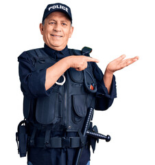 Canvas Print - Senior handsome man wearing police uniform amazed and smiling to the camera while presenting with hand and pointing with finger.