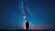 Man staring at the Milky Way galaxy - The vast expanse of the Milky Way stretches above a lone figure standing in a field at night, evoking a sense of wonder