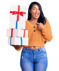 Poster - Hispanic woman with long hair holding gifts smiling happy pointing with hand and finger