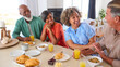 © Monkey Business - Group Of Smiling Mature Friends On Vacation Or At Home Eating Breakfast Together