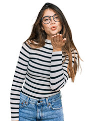 Canvas Print - Young beautiful teen girl wearing casual clothes and glasses looking at the camera blowing a kiss with hand on air being lovely and sexy. love expression.