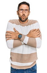 Sticker - Handsome man with beard wearing casual clothes and glasses shaking and freezing for winter cold with sad and shock expression on face