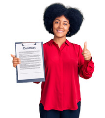 Sticker - Young african american girl holding clipboard with contract document smiling happy and positive, thumb up doing excellent and approval sign