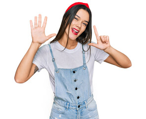 Poster - Young hispanic girl wearing casual clothes showing and pointing up with fingers number seven while smiling confident and happy.