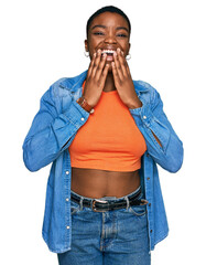 Sticker - Young african american woman wearing casual clothes laughing and embarrassed giggle covering mouth with hands, gossip and scandal concept