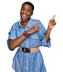 Poster - Young african american woman wearing casual clothes smiling and looking at the camera pointing with two hands and fingers to the side.