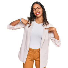 Canvas Print - Young african american girl wearing business clothes looking confident with smile on face, pointing oneself with fingers proud and happy.