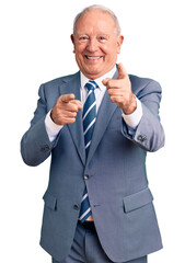 Canvas Print - Senior handsome grey-haired man wearing elegant suit pointing fingers to camera with happy and funny face. good energy and vibes.