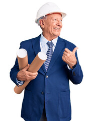 Poster - Senior handsome grey-haired man wearing architect hardhat holding blueprints pointing thumb up to the side smiling happy with open mouth