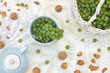 Green grapes in a basket, nuts from a garden on a table with a blue kettle and cup. Top view.