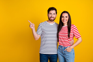 Wall Mural - Photo portrait of lovely young couple hugging point empty space promo wear trendy striped garment isolated on yellow color background