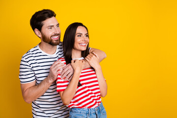 Wall Mural - Photo portrait of lovely young couple hugging look empty space wear trendy striped garment isolated on yellow color background