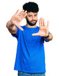 © Krakenimages.com - Young arab man with beard wearing casual blue t shirt doing frame using hands palms and fingers, camera perspective