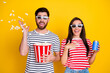 Photo of two overjoyed people watch movie 3d glasses throw pop corn hold soda drink can isolated on yellow color background