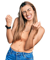 Poster - Hispanic young woman wearing casual summer shirt excited for success with arms raised and eyes closed celebrating victory smiling. winner concept.