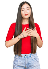 Sticker - Young chinese woman wearing casual clothes smiling with hands on chest with closed eyes and grateful gesture on face. health concept.