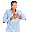 © Krakenimages.com - Young hispanic man wearing casual blue shirt smiling with hands on chest, eyes closed with grateful gesture on face. health concept.