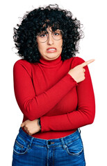 Poster - Young middle east girl wearing casual clothes and glasses pointing aside worried and nervous with forefinger, concerned and surprised expression