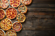 many different pizzas on the wooden table background with copy space
