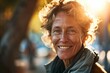 © Iigo - Portrait of a senior woman smiling in the street at sunset.