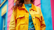 Close-up of a woman in a yellow jacket on a colorful background