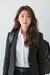 With her full face illuminated by determination, a Korean professional effortlessly blends style and functionality in her business attire