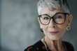 A modern elderly business woman with a stylish pixie haircut and chic glasses captures attention effortlessly. Sophistication, embodying timeless elegance with a contemporary flair.