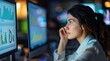 © kardaska - Female journalist looking at quantitative data on a computer screen in a newsroom.