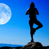Fototapeta Las - Girl on Mountain Top Silhouette Yoga Pose Health and Mental Wellness with Full Moon