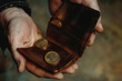 Close-up of a man's hands holding a wallet with coins. A man holds a wallet with several coins in his hand. The problem of inflation, crisis, poverty