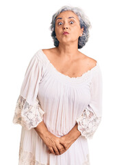 Canvas Print - Senior woman with gray hair wearing bohemian style looking at the camera blowing a kiss on air being lovely and sexy. love expression.