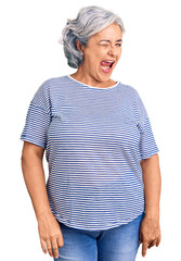 Canvas Print - Senior woman with gray hair wearing casual striped clothes winking looking at the camera with sexy expression, cheerful and happy face.