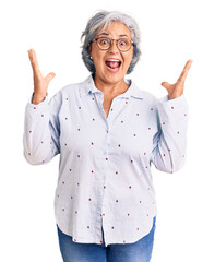 Sticker - Senior woman with gray hair wearing casual business clothes and glasses celebrating victory with happy smile and winner expression with raised hands