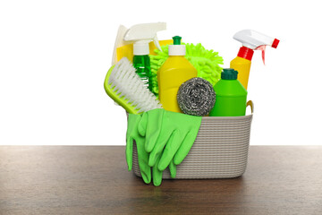 Poster - Different cleaning products in basket on wooden table against white background