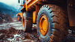 Close-up of a large mining haul truck tire on a rugged dirt road