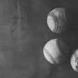 Group of old used baseballs with grunge vintage background in black and white, room for text beside sports equipment.